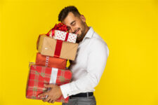 un homme tenant des cadeaux de Noël